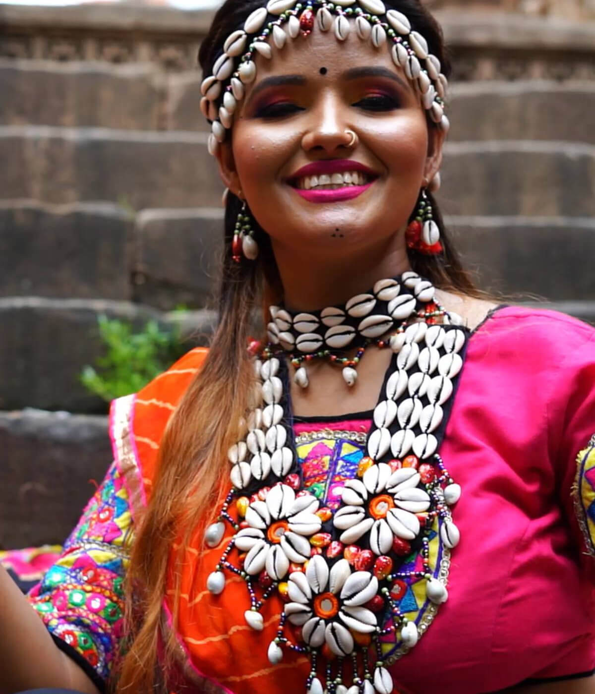 Girl sitting on stairs with Navratri Sea Shell Jewelry and Designer Umbrella